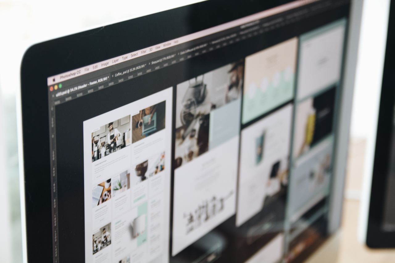 Un écran d’ordinateur moderne montrant un travail de web design, avec des visuels créatifs dans un espace de travail.